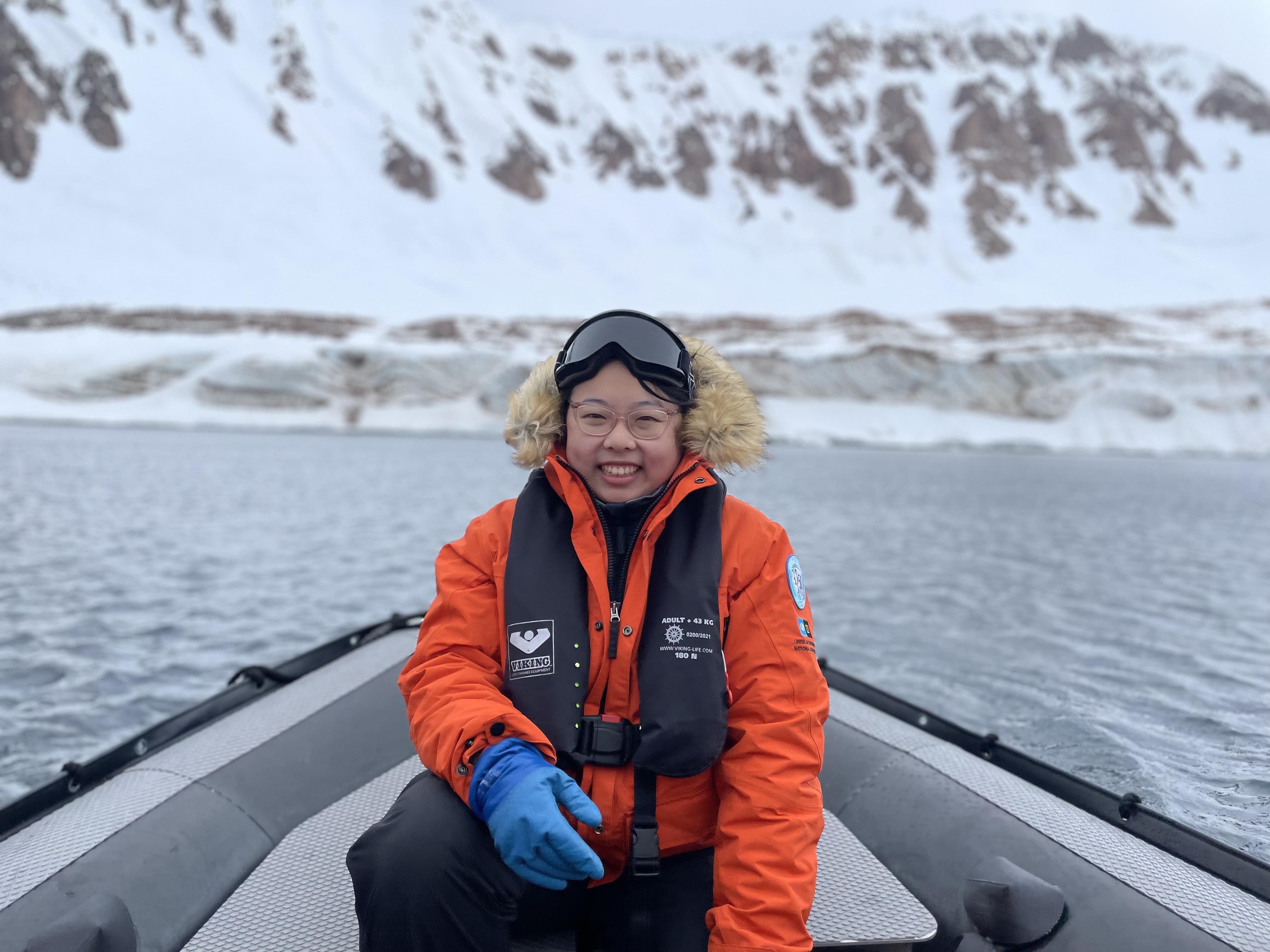 Image of Yueyi Che in boat with glacier in background